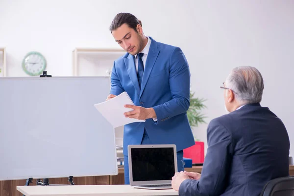 Junge und alte Mitarbeiter im Präsentationskonzept — Stockfoto