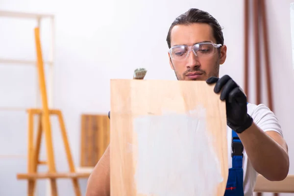 Jonge mannelijke aannemer werkzaam in werkplaats — Stockfoto