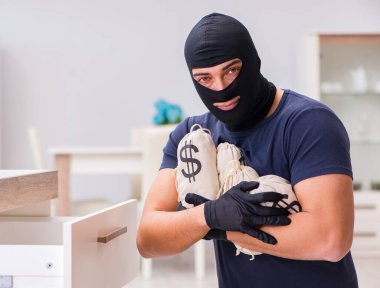 Soyguncu kar maskesi takıp değerli şeyler çalıyor.