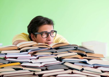 Sınavdan önce okumak için çok fazla kitabı olan öğrenci