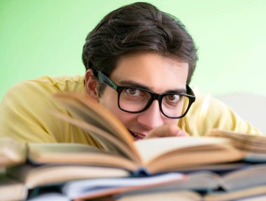 Sınavdan önce okumak için çok fazla kitabı olan öğrenci