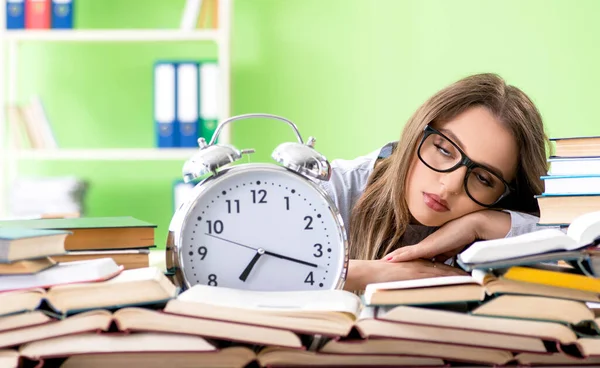 Young female student preparing for exams with many books in time — Stock Photo, Image