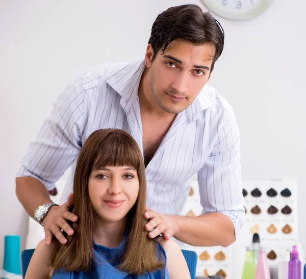 Jovem mulher visitando jovem barbeiro bonito — Fotografia de Stock