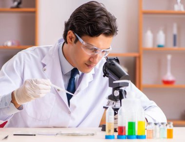 Genç yakışıklı biyokimyacı laboratuvarda çalışıyor.