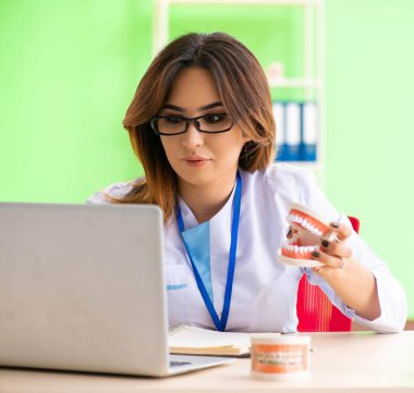 Diş implantı üzerinde çalışan kadın dişçi.