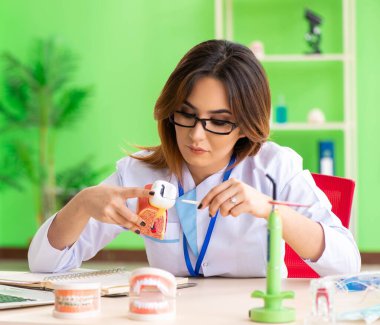 Diş implantı üzerinde çalışan kadın dişçi.