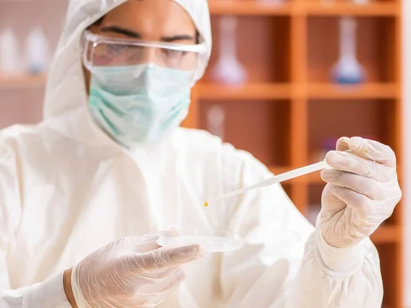 Joven bioquímico con traje protector trabajando en el laboratorio —  Fotos de Stock