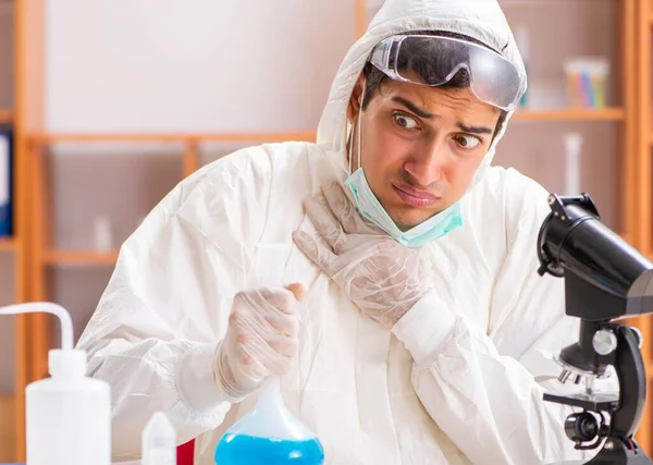 Jovem bioquímico vestindo roupa protetora trabalhando no laboratório — Fotografia de Stock