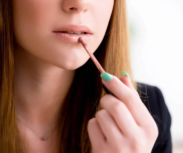 Mujer aplicando lápiz labial con pincel —  Fotos de Stock