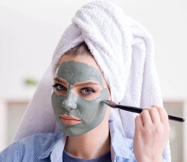 Mujer aplicando mascarilla de barro con cepillo en casa — Foto de Stock