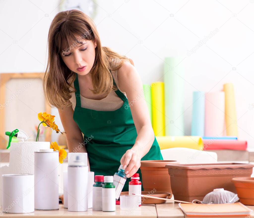 Young woman decorating pottery in workshop