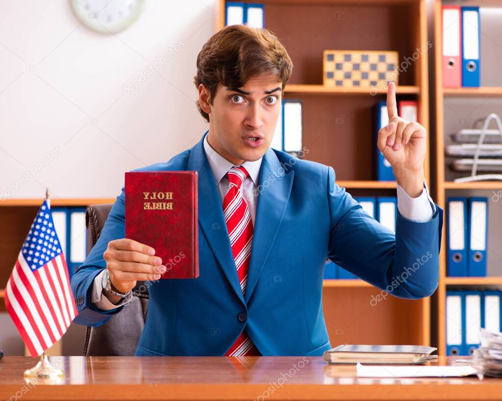 Young handsome politician sitting in office