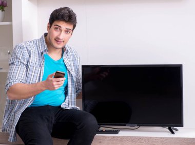 Bozuk televizyonu tamir etmeye çalışan adam