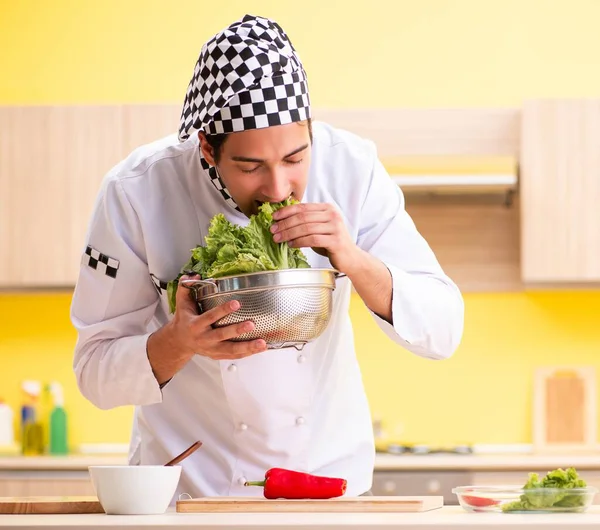 Jovem cozinheiro profissional preparando salada em casa — Fotografia de Stock