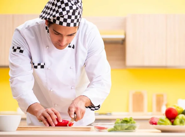 Joven cocinero profesional preparando ensalada en casa — Foto de Stock