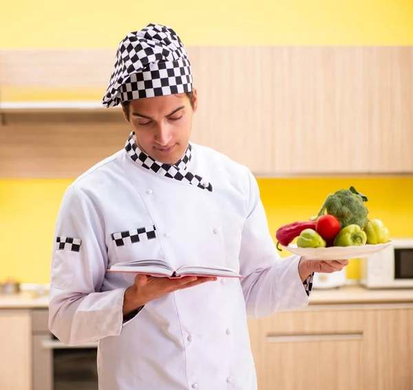 Jovem cozinheiro profissional preparando salada em casa — Fotografia de Stock