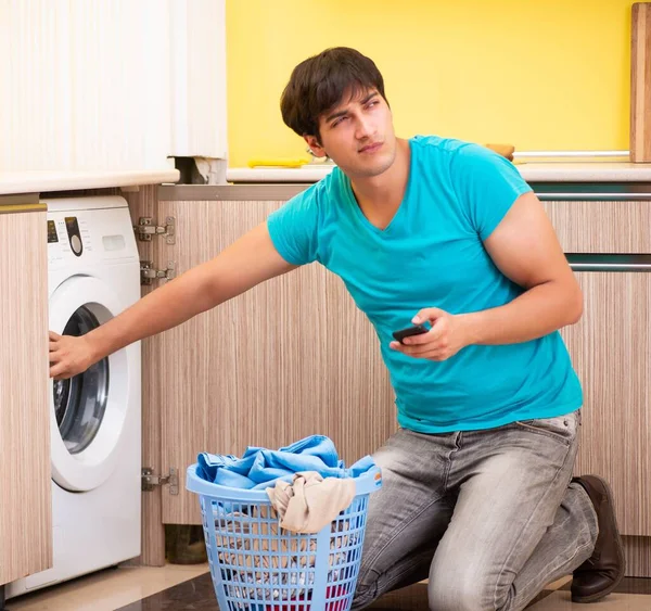 Jovem marido fazendo lavanderia em casa — Fotografia de Stock