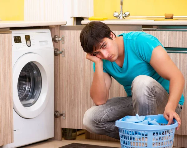 Bărbat tânăr care spală rufe acasă — Fotografie, imagine de stoc