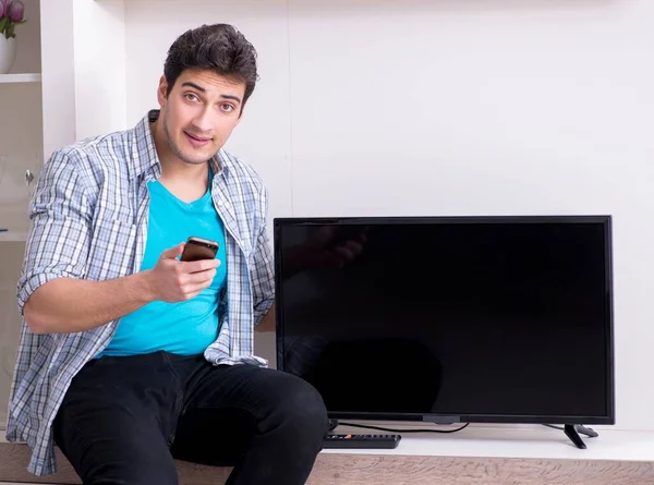 Man trying to fix broken tv — Stock Photo, Image