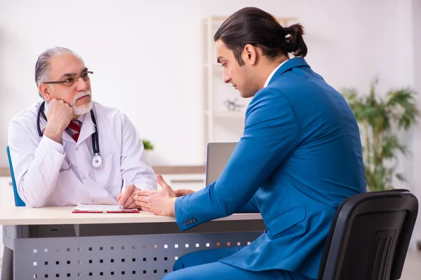 Joven hombre de negocios reunión con el viejo médico — Foto de Stock