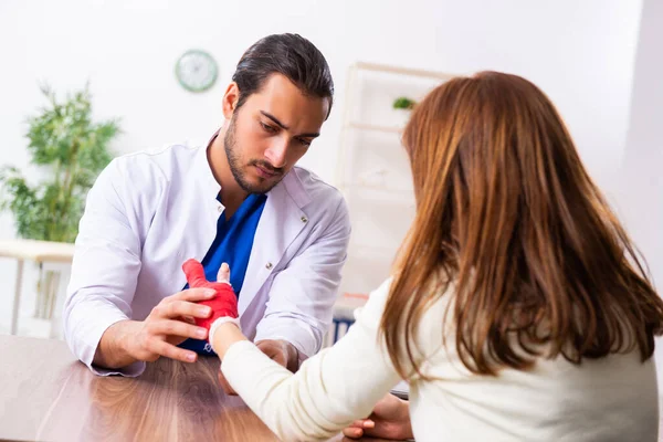 Jovem mão ferida mulher visitando médico traumatologista masculino — Fotografia de Stock