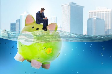 Piggybank ile borç konsepti içinde bir işadamı