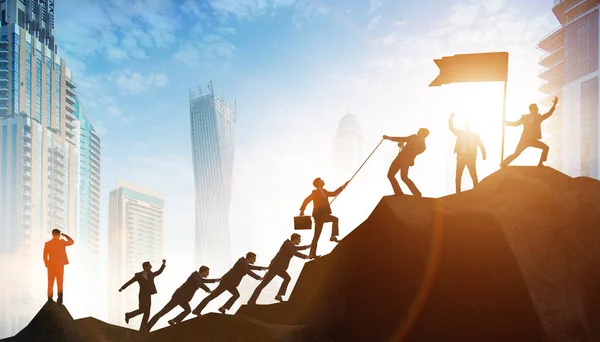 Concept of teamwork with team climbing mountain top — Stock Photo, Image