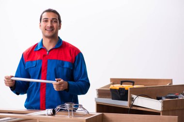 Genç yakışıklı erkek marangoz içeride çalışıyor.