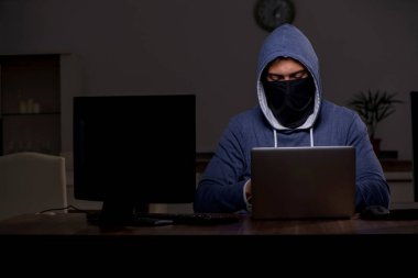 Erkek bilgisayar korsanı, güvenlik duvarını geç saatlerde hackliyor.