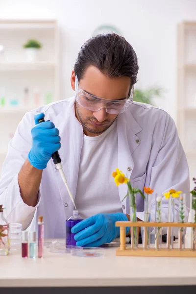 Mladý muž chemik v konceptu syntézy parfémů — Stock fotografie