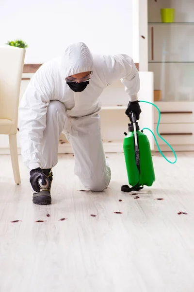 Jovem empreiteiro fazendo controle de pragas em casa — Fotografia de Stock