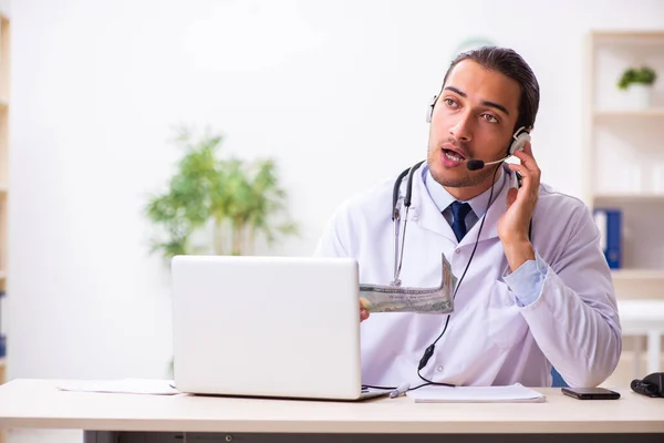 Joven médico escuchando al paciente durante la sesión de telemedicina —  Fotos de Stock