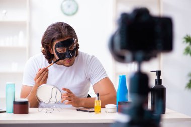 Genç erkek kozmetikçi blogu için video kaydediyor.