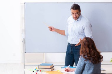 Genç bayan öğrenci ve erkek öğretmen sınıfta.