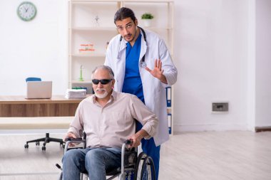 Yaşlı kör adam genç erkek doktoru ziyaret ediyor.