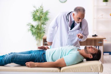 Yaralı genç adam yaşlı doktoru ziyaret ediyor.