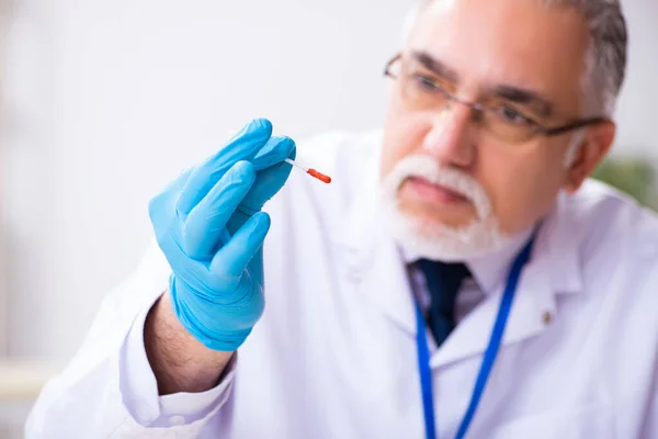 Viejo criminólogo experto trabajando en el laboratorio como evidencia — Foto de Stock