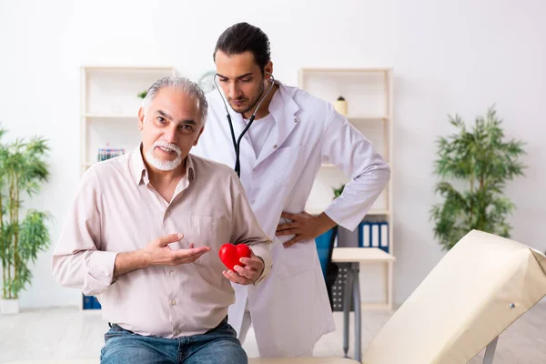 Старик посещает молодого врача-кардиолога — стоковое фото
