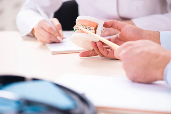 Jonge mannelijke arts stomatoloog en vrouwelijke student in de klas — Stockfoto