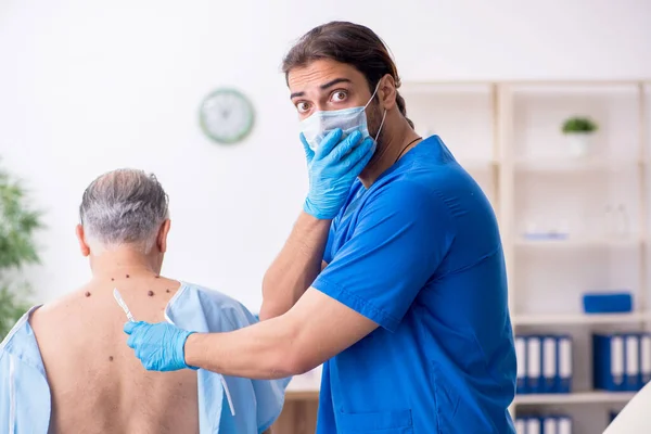 Vecchio visita giovane medico dermatologo maschile — Foto Stock