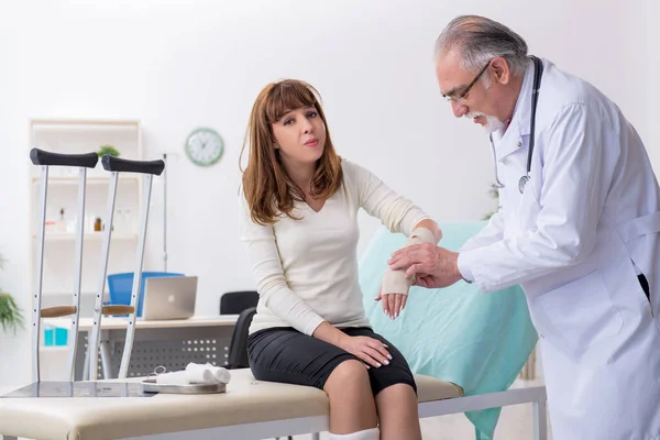 Jovem mulher ferida visitando médico traumatologista experiente — Fotografia de Stock