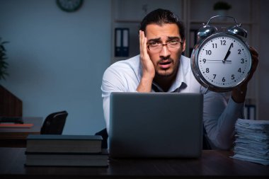 Gece ofiste çalışan genç bir erkek.