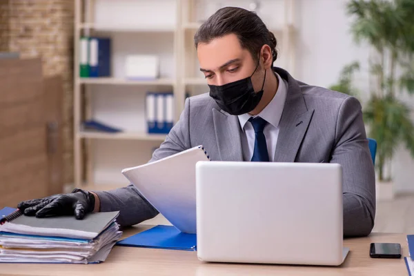 Joven empleado masculino en la oficina durante enfermedad pandémica — Foto de Stock