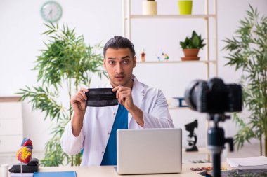 Genç erkek doktor blogu için video kaydediyor.