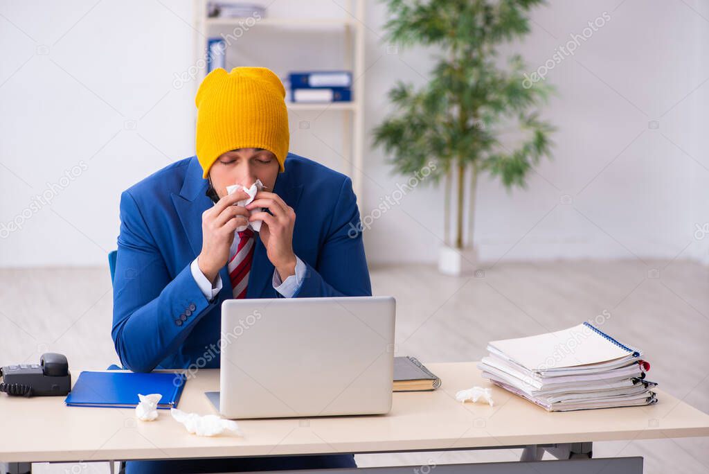 Sick male employee suffering at workplace from coronavirus