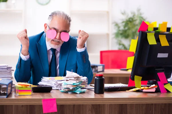 Antiguo empleado que trabaja en la oficina en prioridades contradictorias —  Fotos de Stock