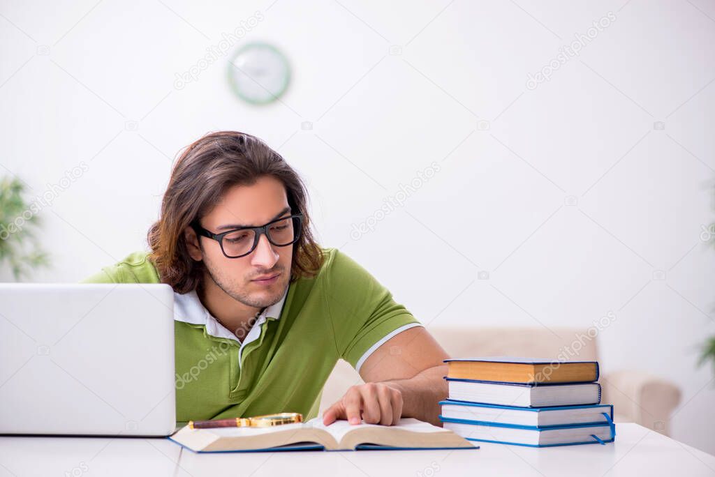 Young male student preparing for exams at home