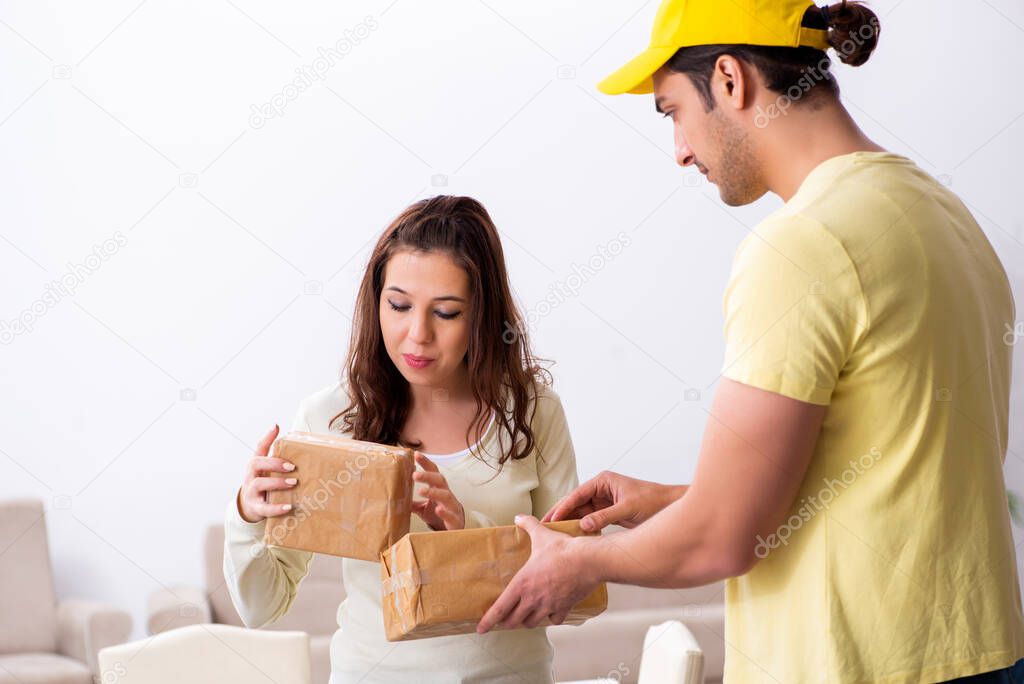 Young male courier delivering parcel to the office