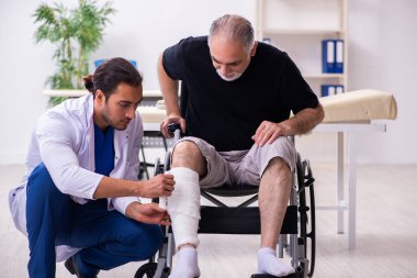 Yaşlı adam genç doktor travmatoloğu ziyaret ediyor.