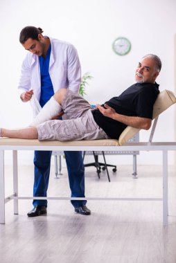Yaşlı adam genç doktor travmatoloğu ziyaret ediyor.